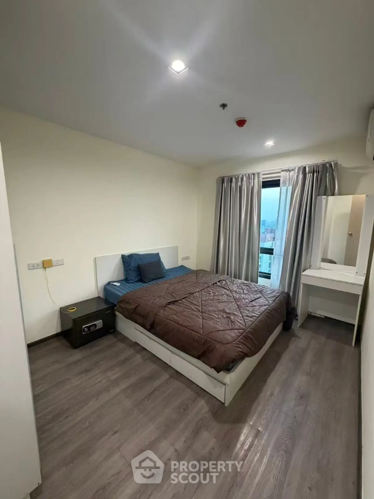 Modern bedroom with cozy bed and city view from window