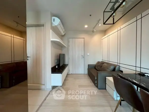 Modern living room with sleek design, featuring a comfortable sofa, wall-mounted TV, and stylish dining area.