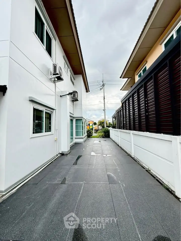 Modern exterior view of a residential building with sleek design and spacious driveway.