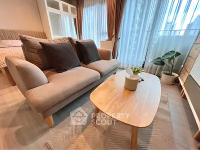 Modern living room with cozy sofa and wooden coffee table, featuring large windows and elegant curtains.