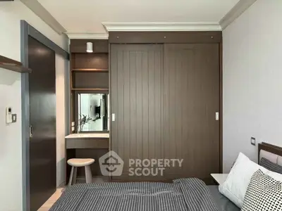 Modern bedroom with sleek wooden wardrobe and cozy bedding in a stylish apartment.