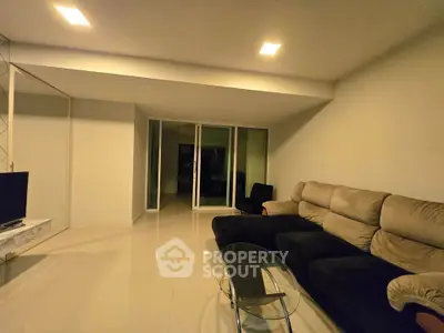 Spacious modern living room with sleek furniture and ambient lighting