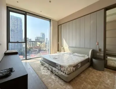 Luxurious bedroom with floor-to-ceiling windows offering stunning city views, modern furnishings, and elegant decor.