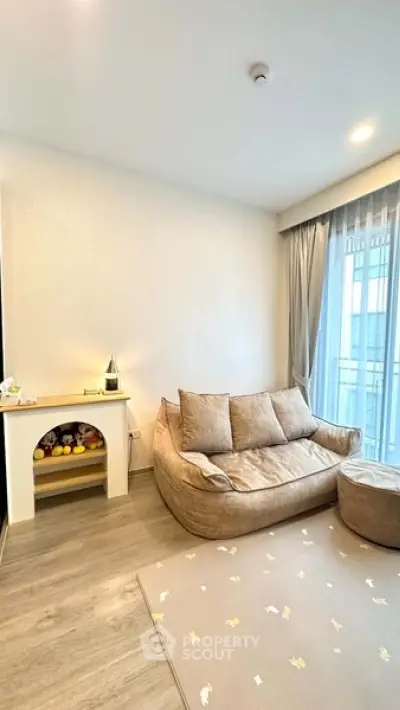 Cozy living room with plush sofa and natural light from large window.