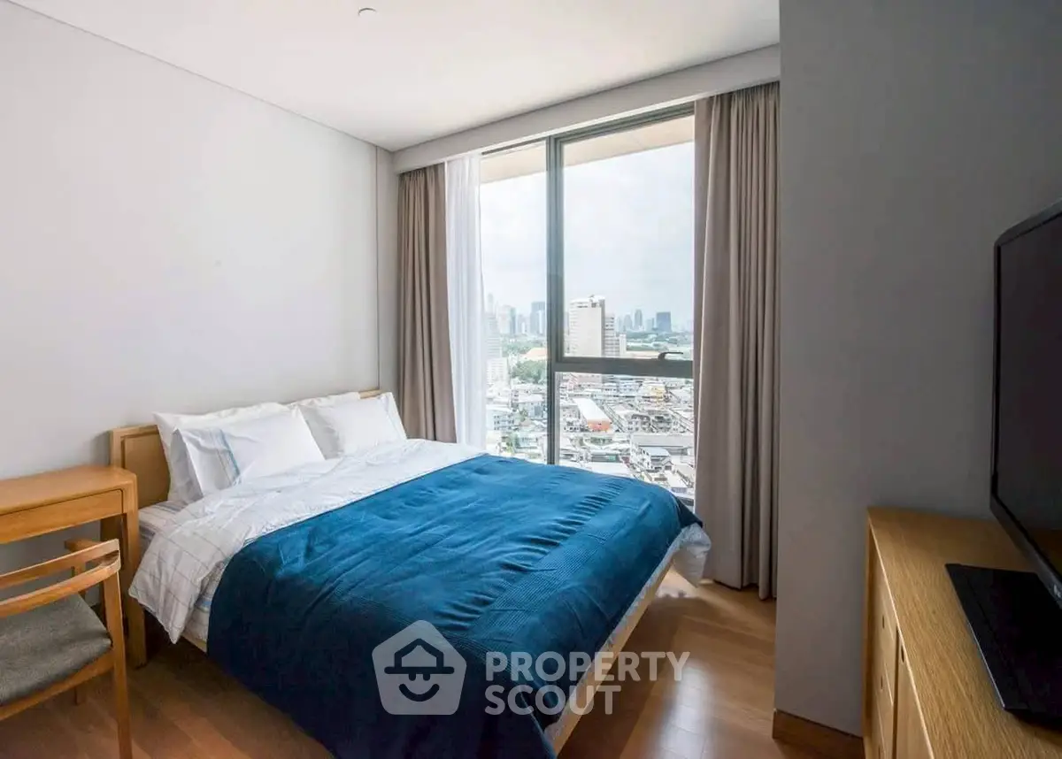 Modern bedroom with city view, featuring a cozy bed and stylish furnishings.