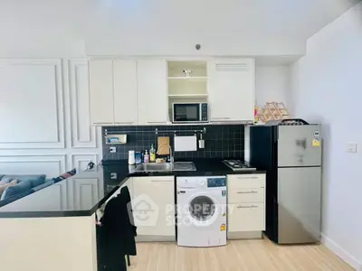 Modern kitchen with sleek appliances and washing machine in open layout