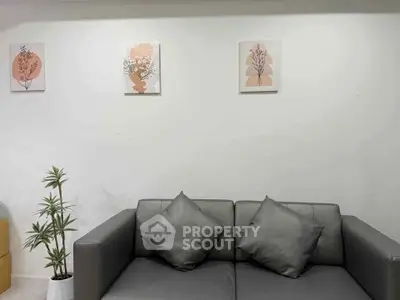 Modern living room with stylish gray sofa and minimalist wall art, perfect for contemporary home decor.