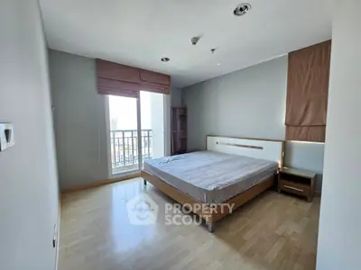 Spacious bedroom with modern design and large window offering natural light and city views.