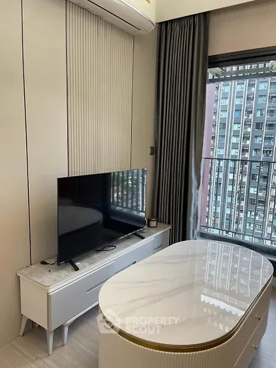 Modern living room with sleek TV setup and city view from balcony.
