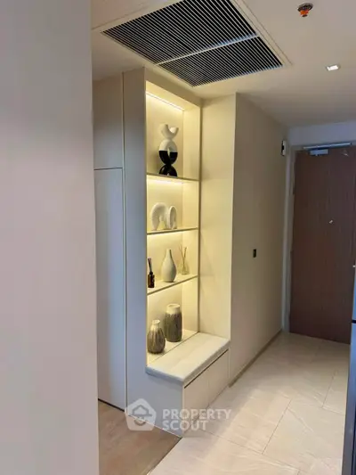 Stylish modern hallway with built-in shelving and elegant decor in a contemporary apartment.