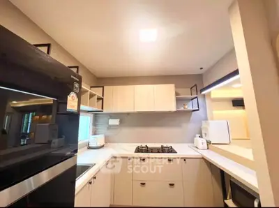 Modern kitchen with sleek cabinetry and gas stove in a cozy apartment