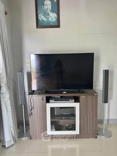 Modern living room with sleek TV setup and stylish speakers