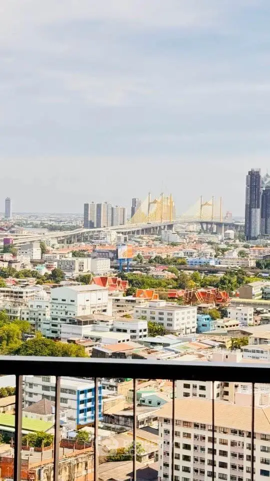 Stunning cityscape view from high-rise balcony overlooking iconic bridge and skyline.