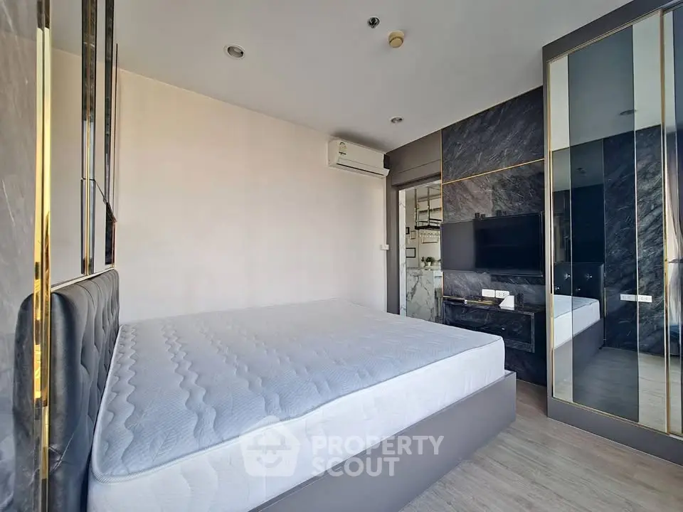 Modern bedroom with stylish decor and large mirror wardrobe in a contemporary apartment.