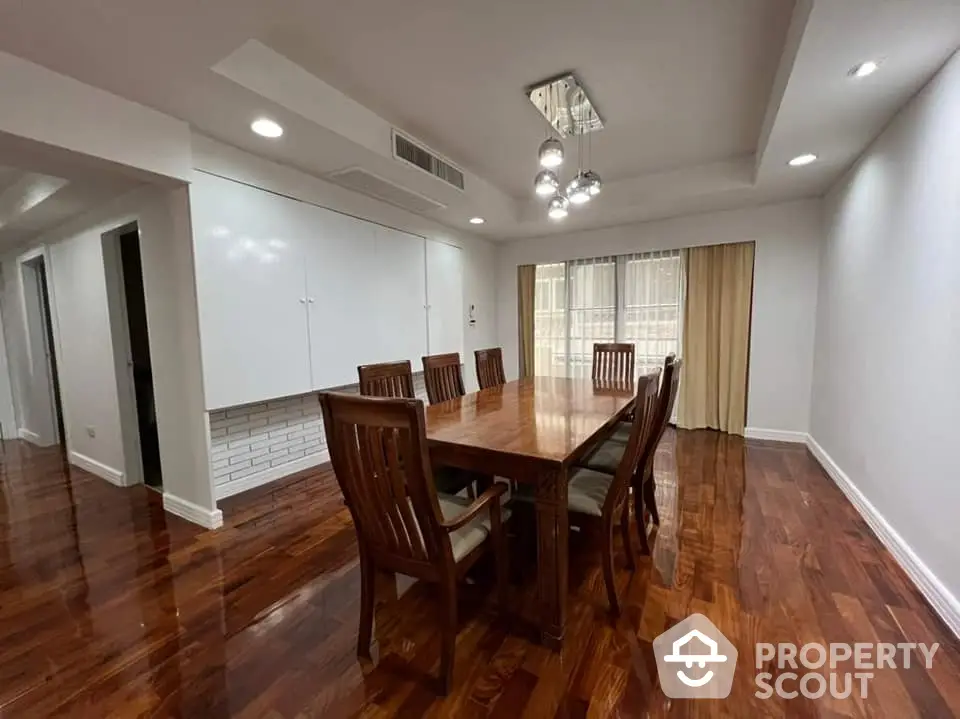 Elegant dining room with polished wooden floors and modern lighting