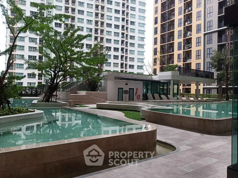 Luxurious condominium pool area with modern architecture and lush greenery