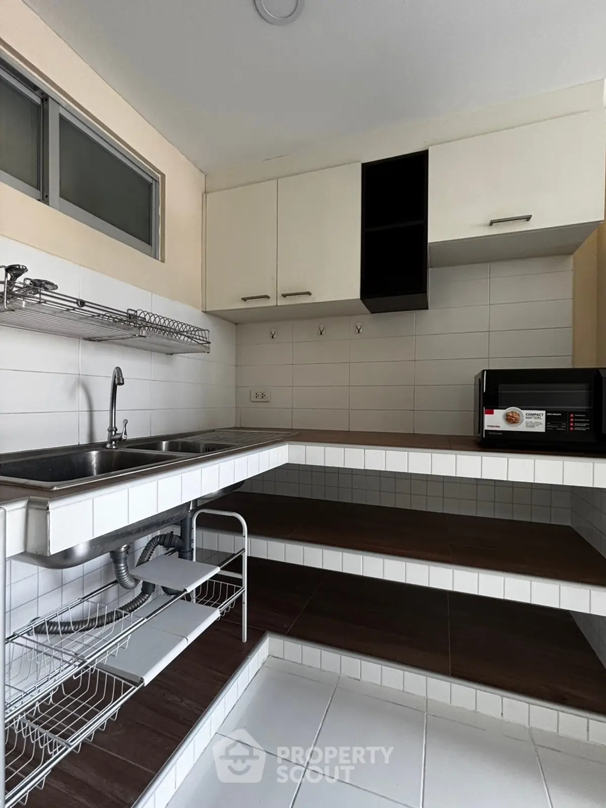 Modern kitchen with sleek design, featuring a stainless steel sink and ample storage space.