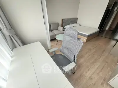 Modern studio apartment with cozy bed, stylish desk, and comfortable seating area.