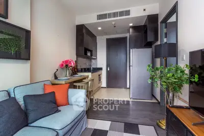 Modern living room with open kitchen, stylish decor, and cozy seating area in a contemporary apartment.