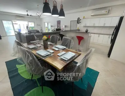 Spacious open-plan living and dining area with modern kitchen and stylish decor.