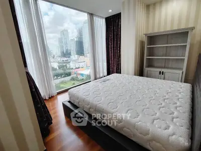 Modern bedroom with large window offering stunning city view in high-rise apartment