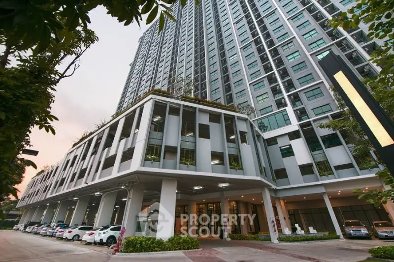 Modern high-rise building with parking and lush greenery