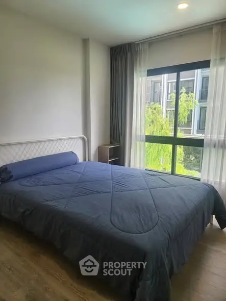 Cozy bedroom with large window and modern decor in a stylish apartment.