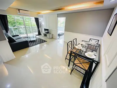 Spacious modern living and dining area with natural light and stylish decor.