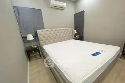 Cozy bedroom with elegant tufted headboard and modern air conditioning unit.