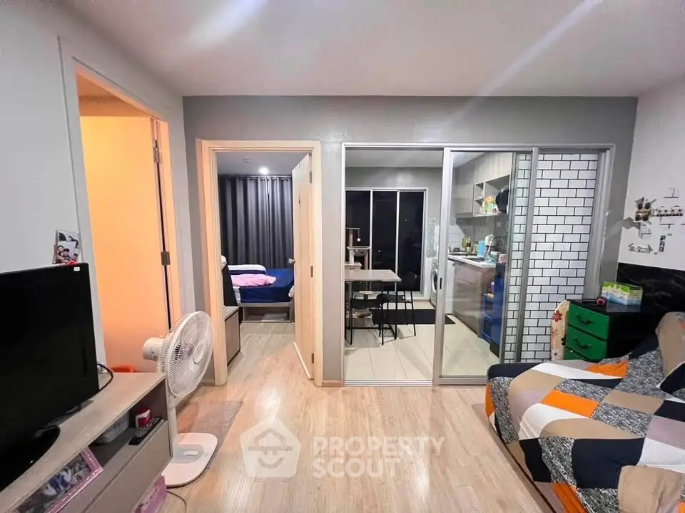 Modern apartment interior with open layout, featuring a cozy living area and adjacent kitchen.