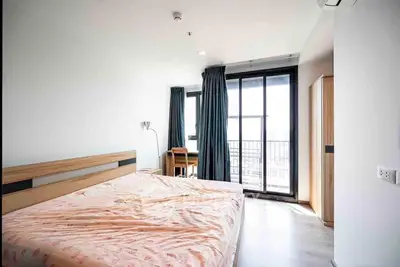 Spacious bedroom with gleaming floors, large windows offering ample natural light, and a cozy ambiance perfect for relaxation.