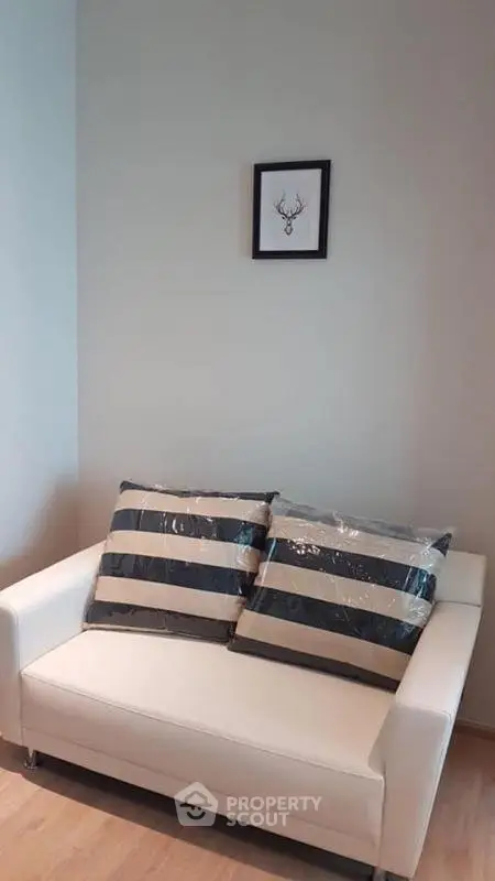 Cozy living room with white sofa and stylish decor in modern apartment.