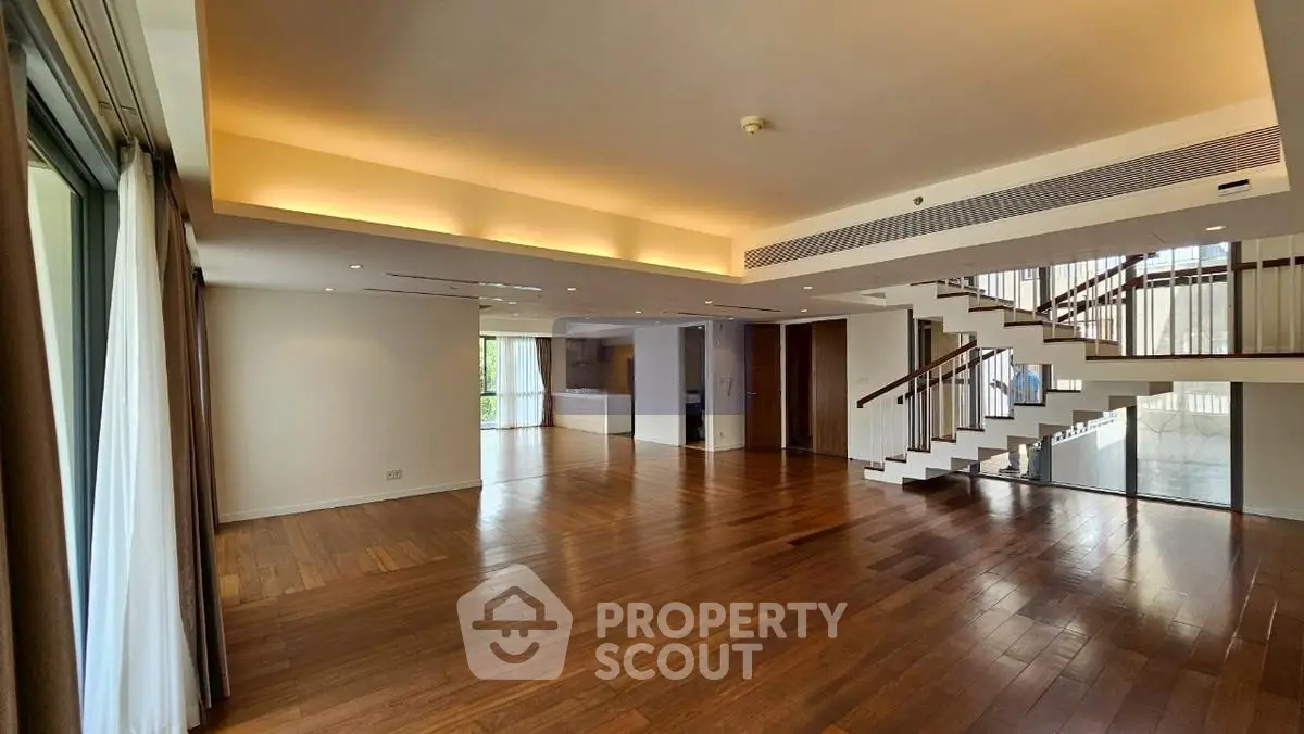 Spacious modern living room with wooden floors and staircase