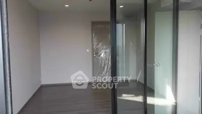 Spacious empty room with sliding glass doors and modern flooring, perfect for customization.