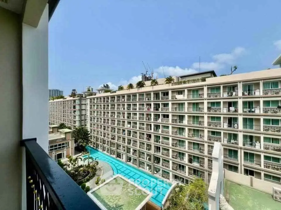 Stunning view of modern apartment complex with pool and lush greenery.