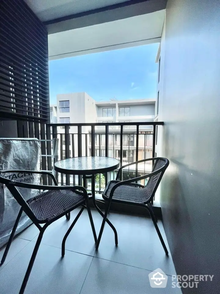 Charming balcony with modern seating and scenic view of contemporary buildings.