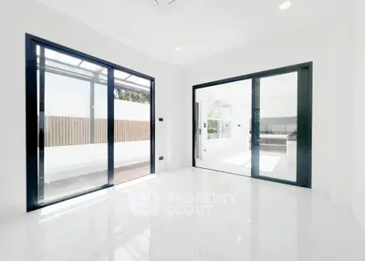 Bright modern interior with large sliding glass doors and glossy white flooring