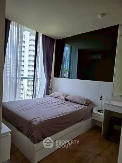 Modern bedroom with floor-to-ceiling windows and city view, featuring sleek design and natural light.