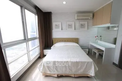 Modern bedroom with large windows and stylish decor in a high-rise apartment.