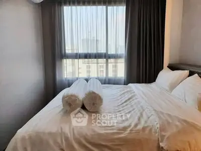 Cozy bedroom with large window and elegant curtains, perfect for relaxation and comfort.