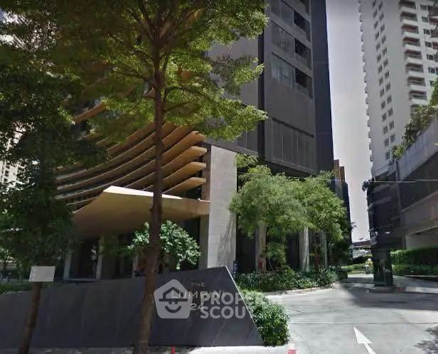 Modern high-rise building entrance with lush greenery at The Lumpini 24