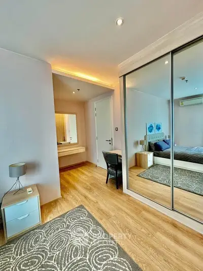 Modern bedroom with mirrored closet and stylish decor in a cozy apartment.