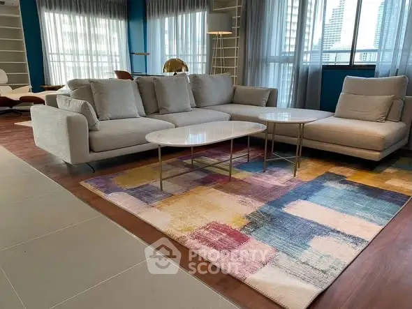Spacious modern living room with stylish furniture and colorful rug, perfect for relaxation.