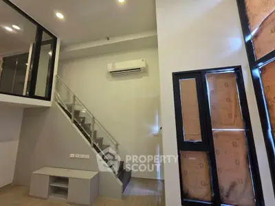 Modern duplex interior with staircase and air conditioning unit