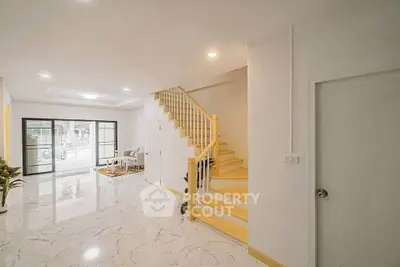 Spacious modern living room with elegant staircase and marble flooring