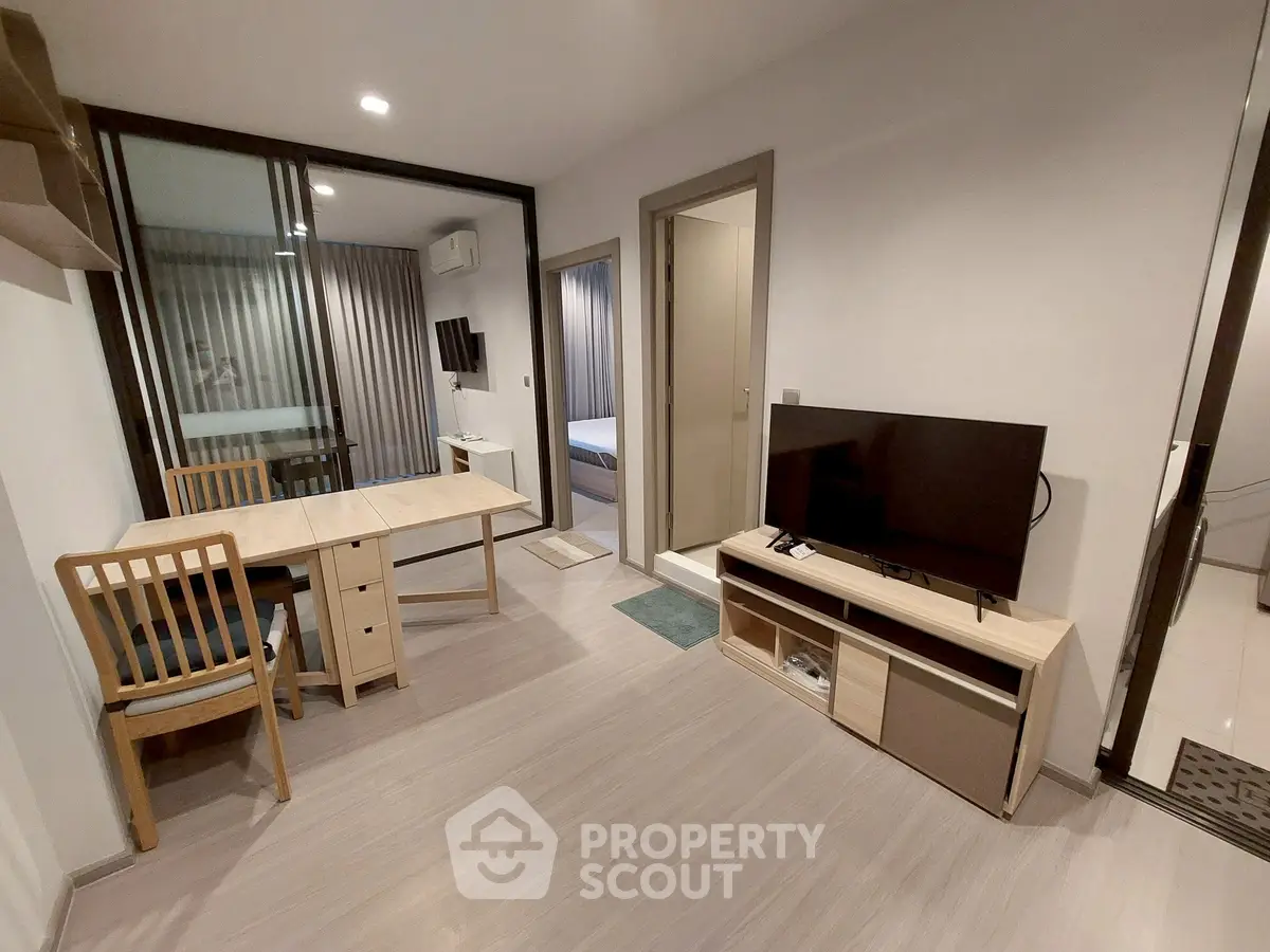 Modern living room with TV and dining area in open layout apartment