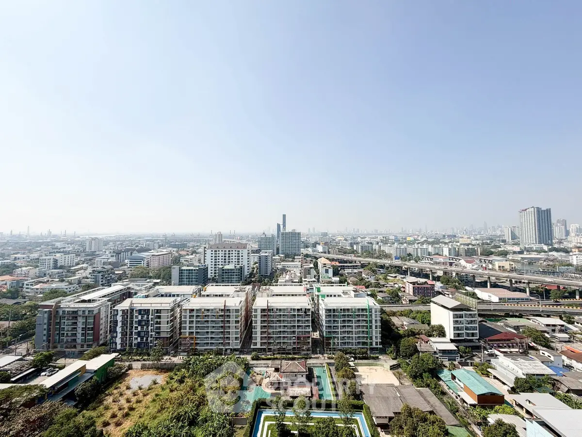 Stunning panoramic cityscape view from high-rise building, showcasing urban skyline and residential areas.