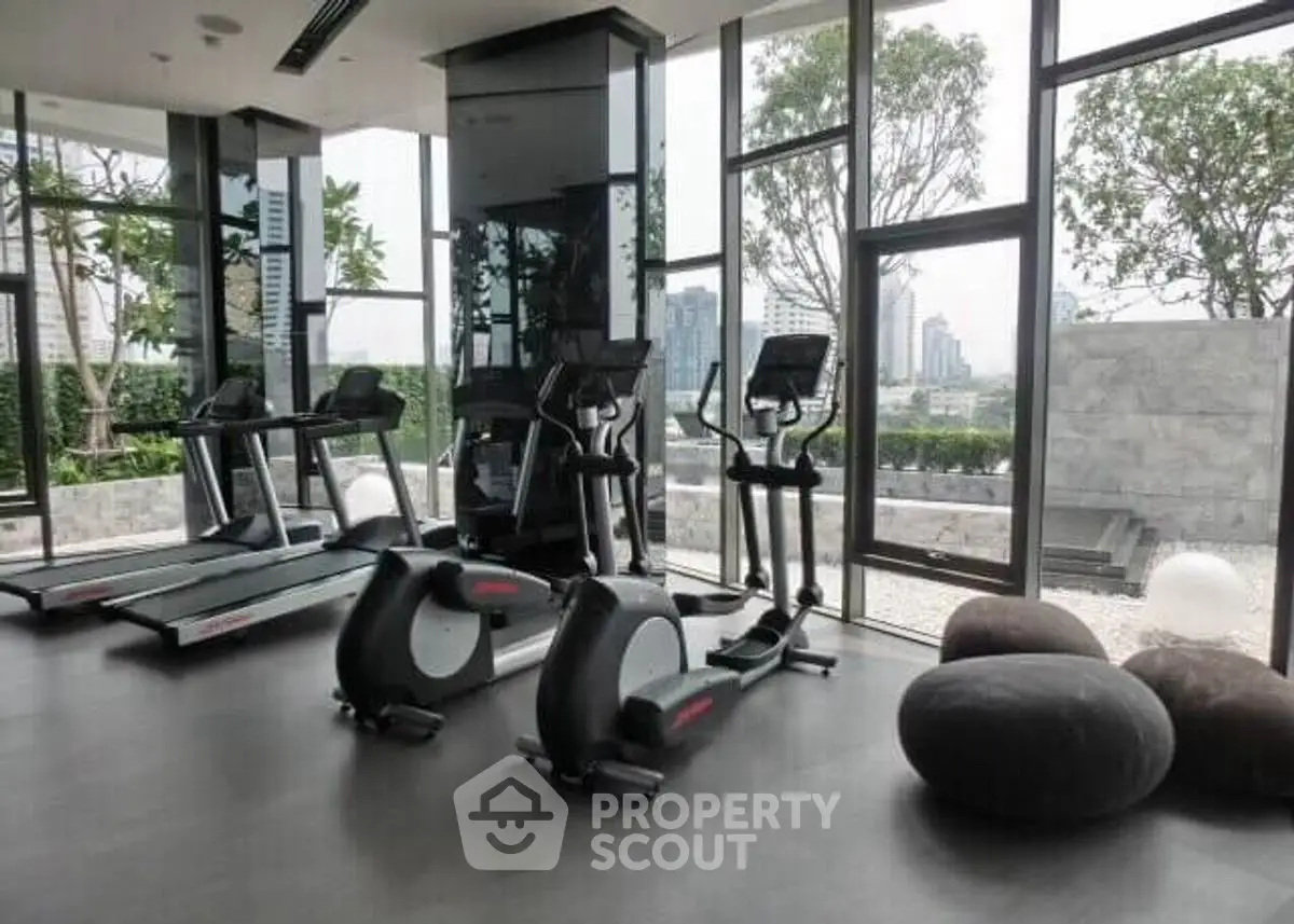 Modern gym with city view and exercise equipment in luxury building