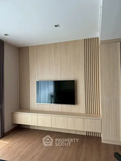 Modern living room with sleek wooden paneling and wall-mounted TV