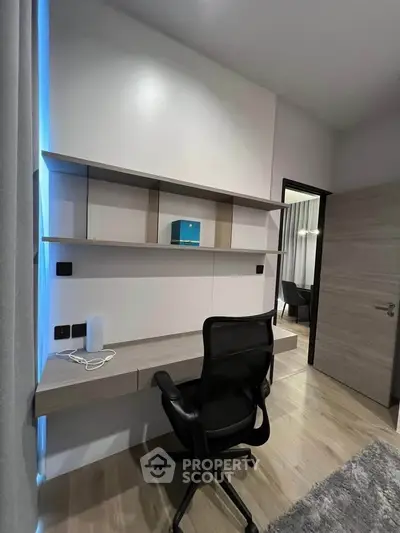 Modern study room with sleek desk, ergonomic chair, and stylish shelving in a contemporary home.